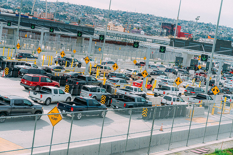 汽车在蒂华纳/圣伊西德罗穿过美墨边境进入美国加利福尼亚州圣地亚哥的高角度长焦视图